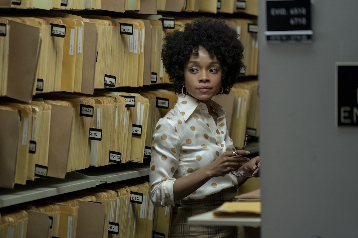 Rachel Hilson in 'Duster,' as FBI Agent Nina Hayes, shown in the file room wearing a white shirt with yellow polka dots