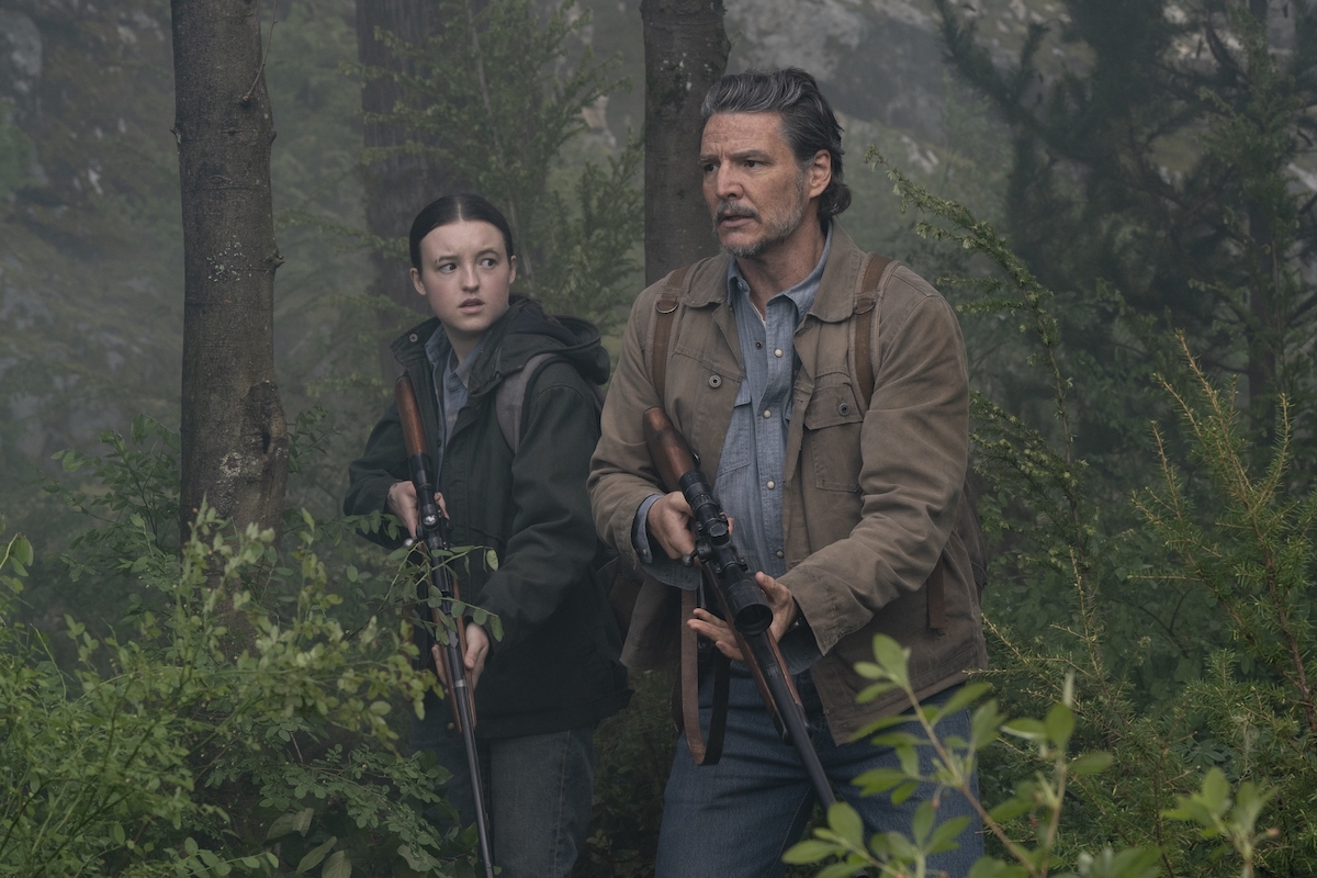 Bella Ramsey and Pedro Pascal in 'The Last of Us' Season 2 Episode 6, shown walking through the woods together, guns out