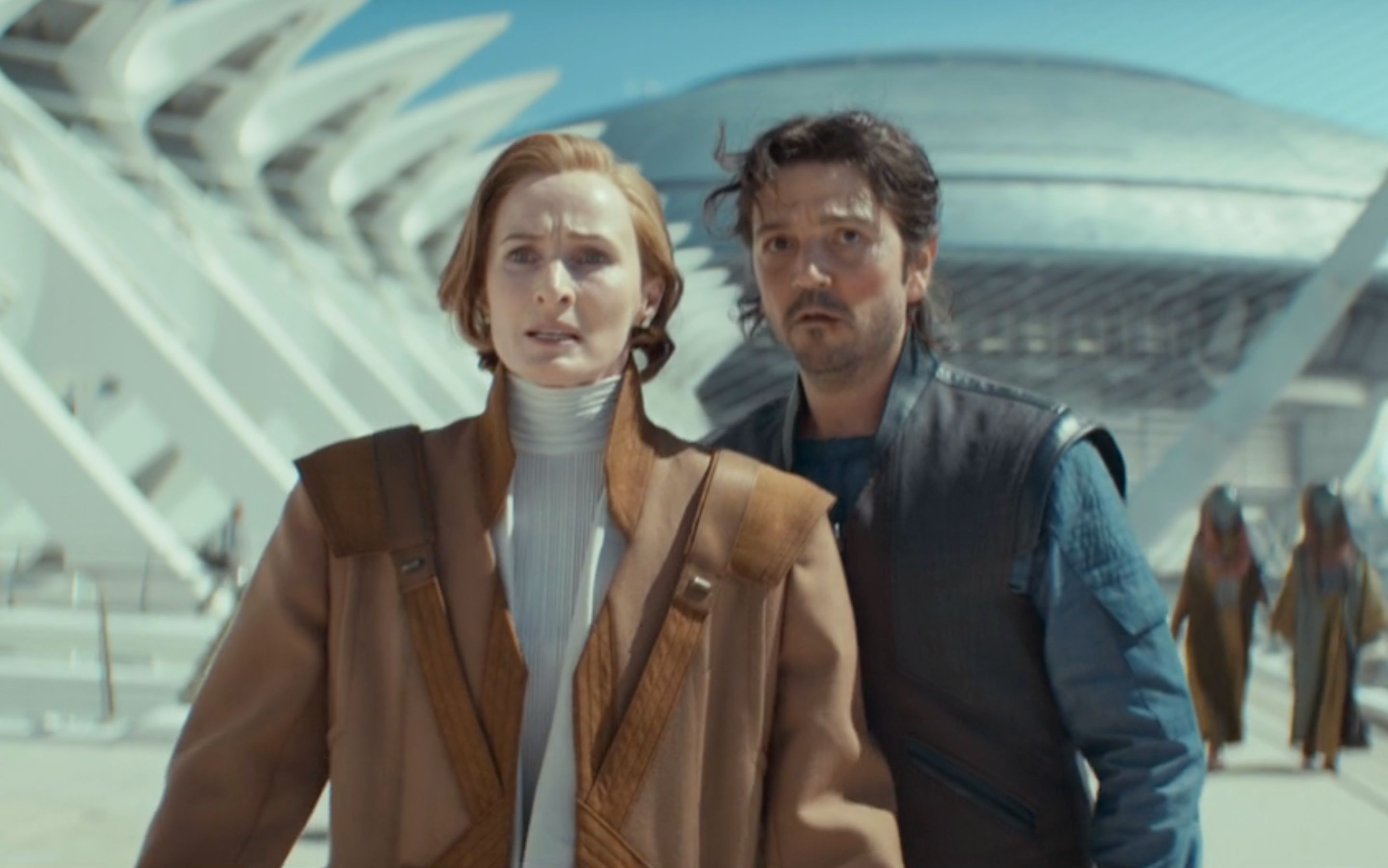 Diego Luna and Genevieve O'Reilly in Episode 9 of 'Andor' Season 2, standing outside the senate building looking nervous as they try to escape.