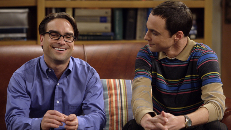 Leonard and Sheldon sitting on the couch smiling in "The Big Bang Theory"
