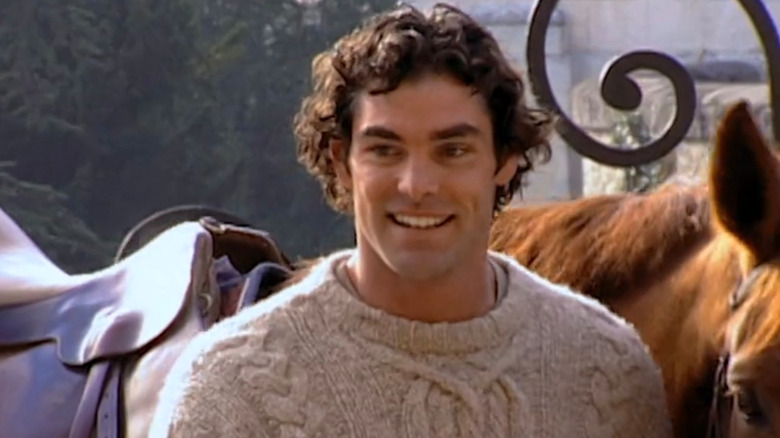 Evan Marriott smiling next to his horse in "Joe Millionaire"