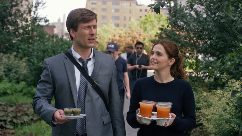Charlie and Harper walking with drinks in Set It Up