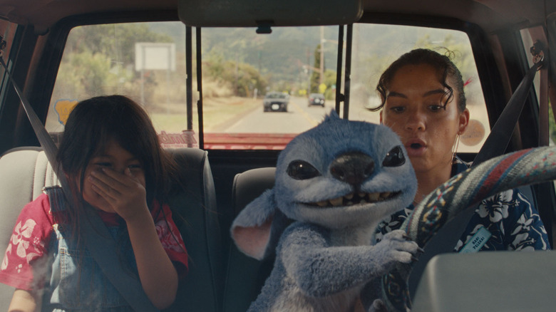 Stitch taking over the wheel of Nani's truck while Lilo giggles