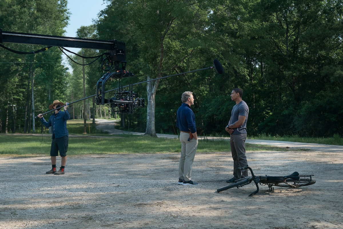 Rebel Ridge stars Don Johnson as Chief Sandy Burnne and Aaron Pierre as Terry Richmond, shown here on the set of 'Rebel Ridge,' standing outside, looking at each other, bike on the ground