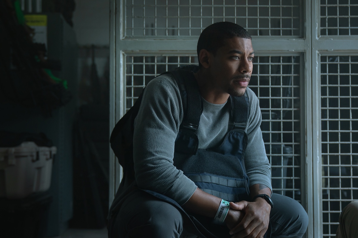 Rebel Ridge stars Aaron Pierre as Terry Richmond, shown here sitting in thought, wearing a bookbag over the front of his chest