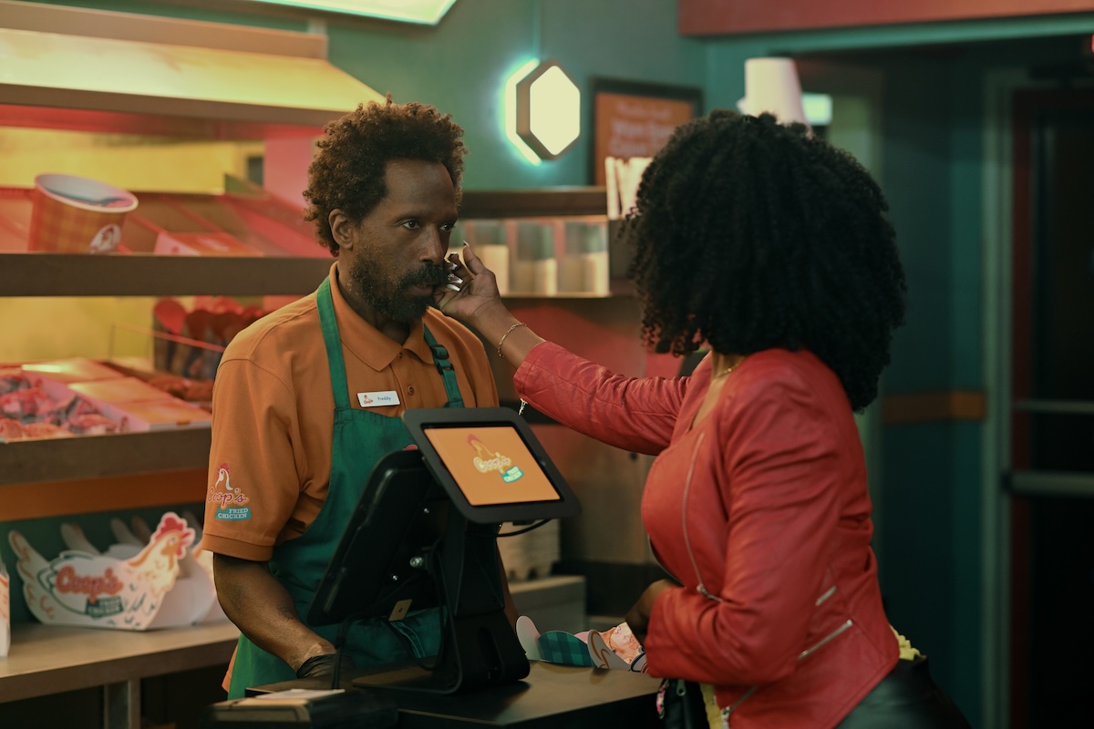 Ntare Guma Mbaho Mwine in 'Smoke,' shown standing behind the register at a fast-food restaurant as a customer strokes his cheek