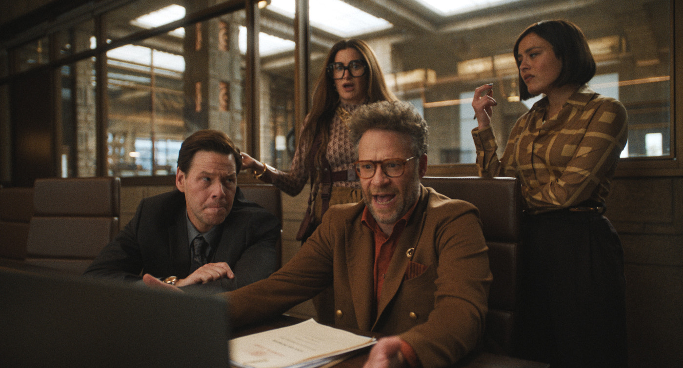 'The Studio' stars Seth Rogen, Ike Barinholtz, Chase Sui Wonders, and Kathryn Hahn, shown here in a conference room looking over Rogen's shoulder at a computer