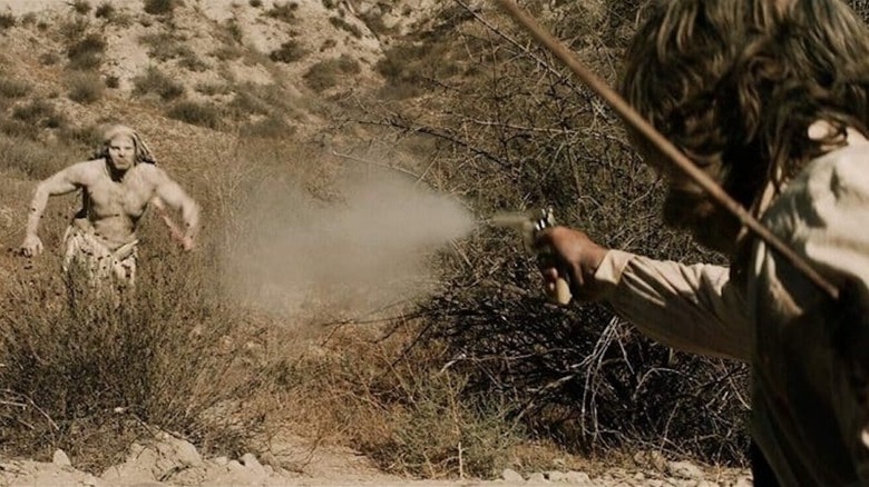 John Brooder fires a pistol at a charging Troglodyte in "Bone Tomahawk" (2014)