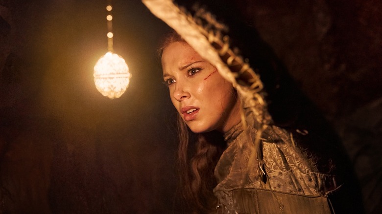 Elodie looking into the darkness in Damsel (2024)