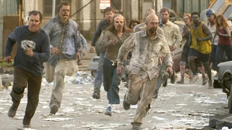 Decaying zombies run through a littered street in "Dawn of the Dead" (2004)