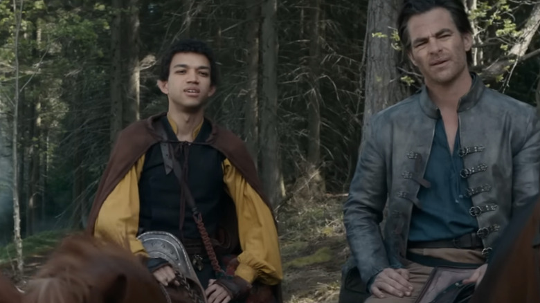Sorcerer Simon Aumar (Justice Smith) and bard Edgin Darvis sitting horseback