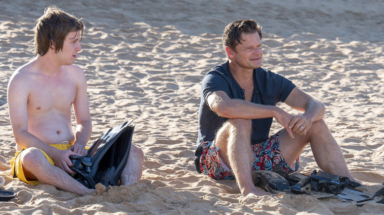 Quinn and Mark talk on the beach in "The White Lotus"