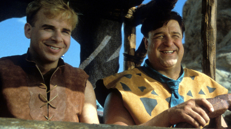 Barney and Fred ride in a car in "The Flintstones" (1994)