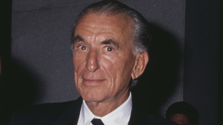 Herbert Ross wearing a suit and tie in 1990