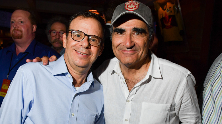 Eugene Levy with his arm on Rick Moranis's shoulder