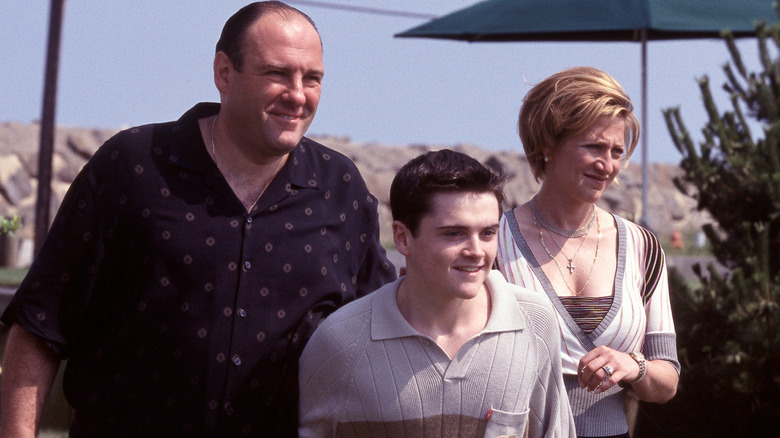 Tony, AJ, and Carmela standing outside smiling