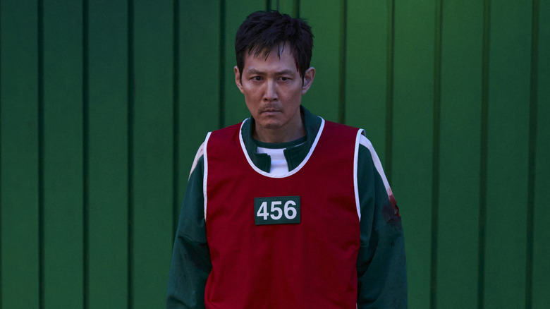 Gi-hun in a red vest with his number on Squid Game (2025)