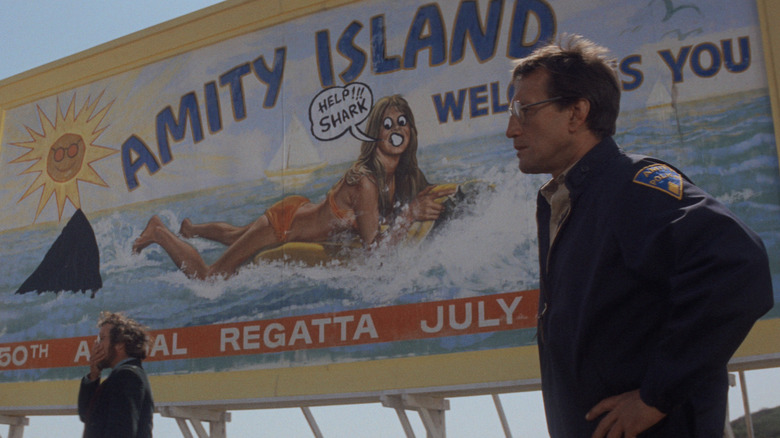 Vaughn standing in front of defaced sign in "Jaws"