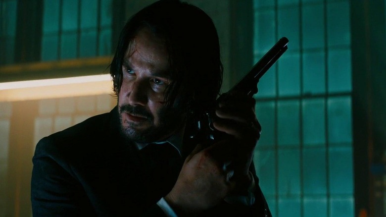 John Wick clutching a gun for battle
