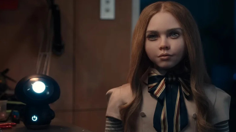 M3GAN standing next to a camera in "M3GAN" (2023)