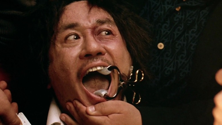 Oh Dae-su cackles while getting tortured in "Oldboy" (2003)