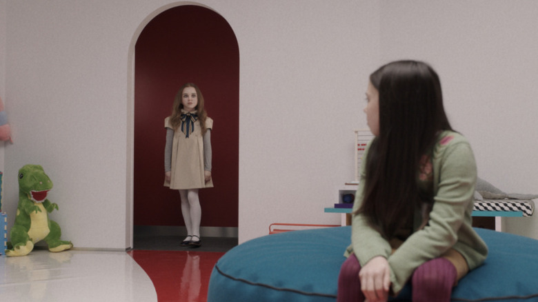M3GAN standing in a doorway while Cady watches in "M3GAN" (2023)