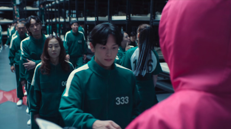 Player 152 mewing her jawline in the background in Squid Game Season 2