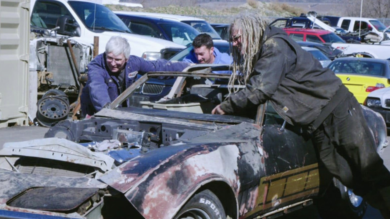 Mike and Connor helping push old Trans Am in junkyard