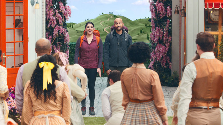 Melissa and Josh looking at the townspeople in Schmigadoon