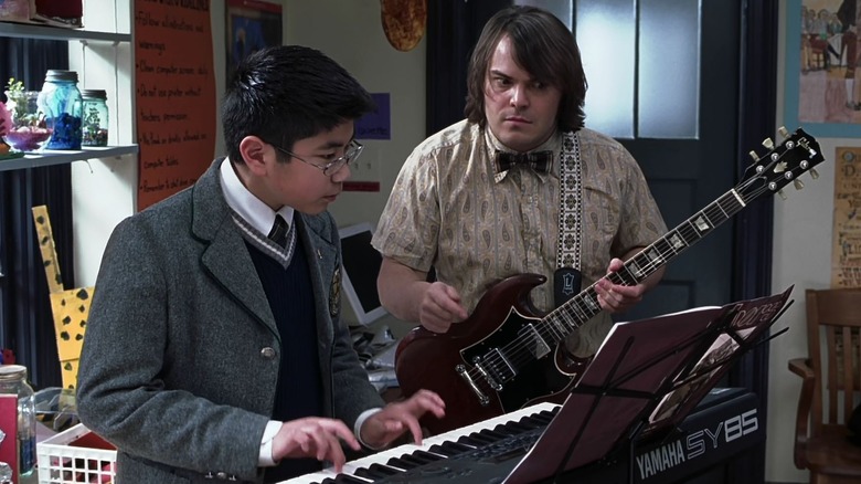 Dewey (Jack Black) helping his student, Lawrence (Robert Tsai) play the keyboard