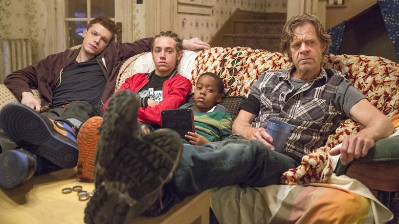 Ian, Carl, Liam, and Frank sitting on the couch in "Shameless" (2011-2021)