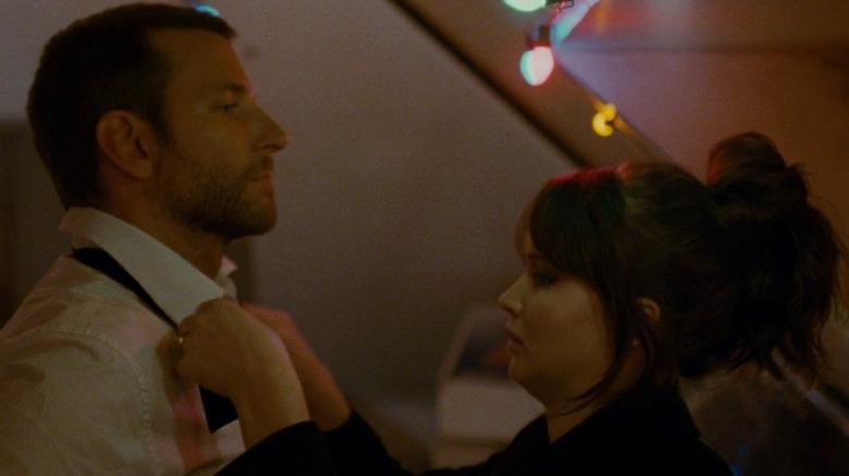Tiffany (Jennifer Lawrence) fixing Pat's (Bradley Cooper) bowtie