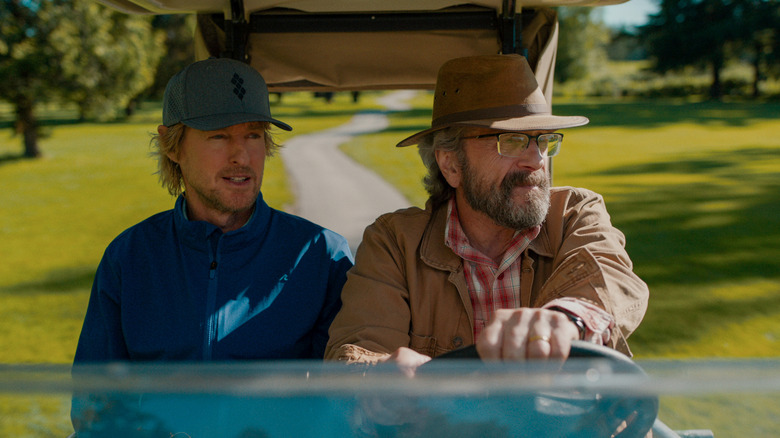 Pryce and Mitts in a golf cart on Stick