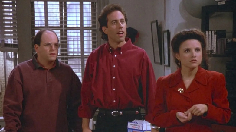 Jerry, George, and Elaine stand by a window in "The Contest"