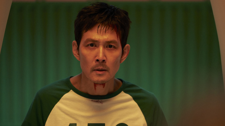 Gi-hun in his player shirt looking shocked on Squid Game