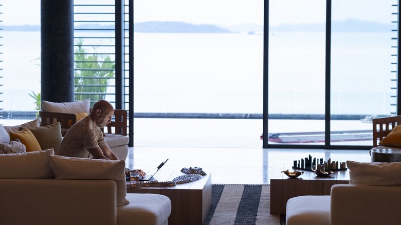 Greg Hunt working on his laptop in "The White Lotus"