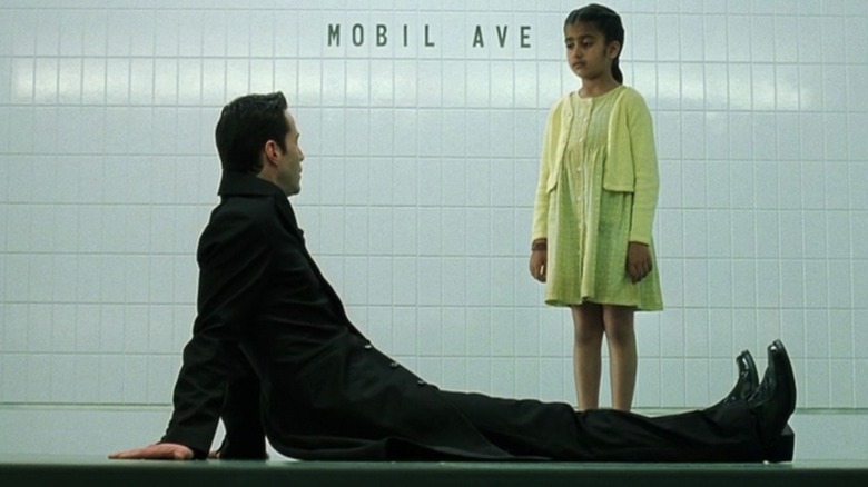 Neo talks to a little girl at a train station in "The Matrix Revolutions" (2003)