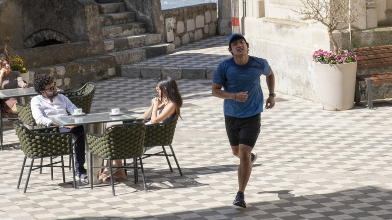 Ethan Spiller runs on a city street in "White Lotus"