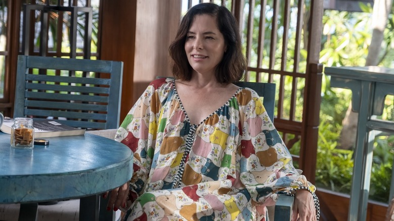 Victoria sitting at a table in "The White Lotus."