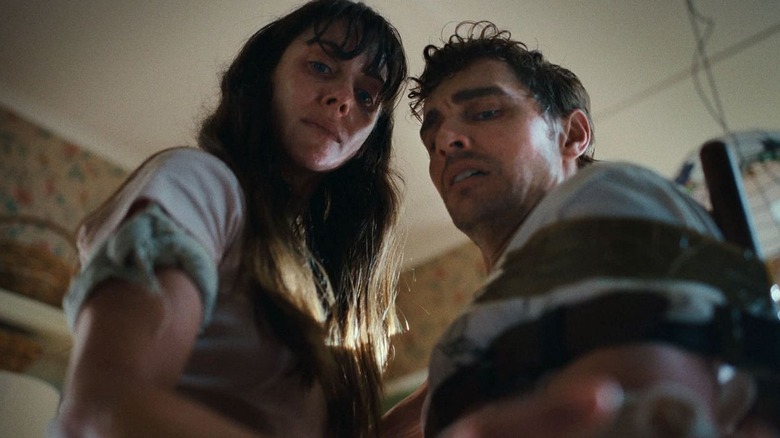 Millie and Tim look down in "Together" (2025)