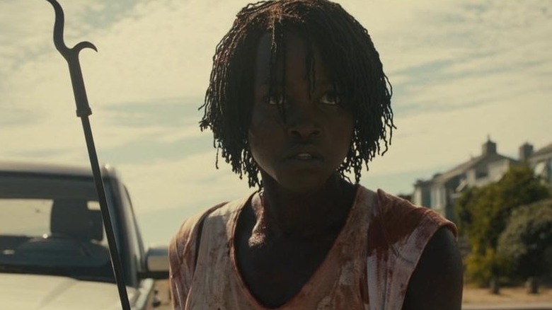 Adelaide holds a fireplace poker in "Us" (2019)