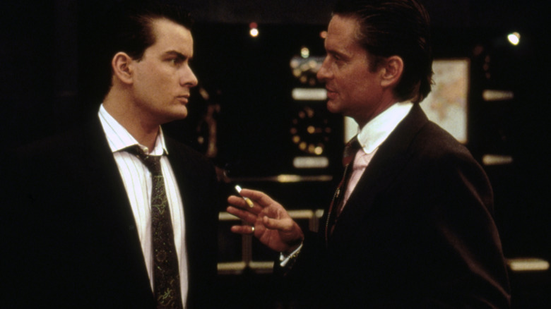 Gordon holds a cigarette as he talks to Bud in Wall Street (1987)