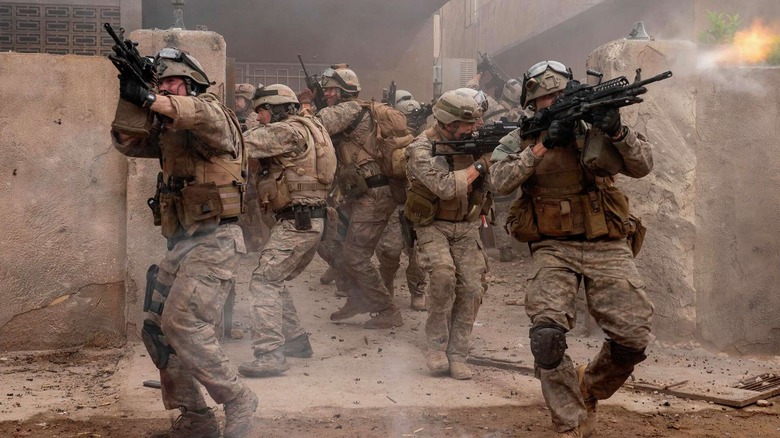 soldiers exit a compound shooting and aiming guns in "Warfare" (2025)