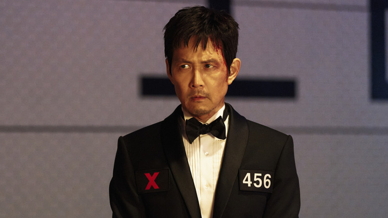 Gi-hun in a tuxedo with his number on it in Squid Game