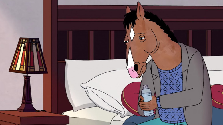BoJack sits sullenly on his bed holding a bottle of water in BoJack Horseman.