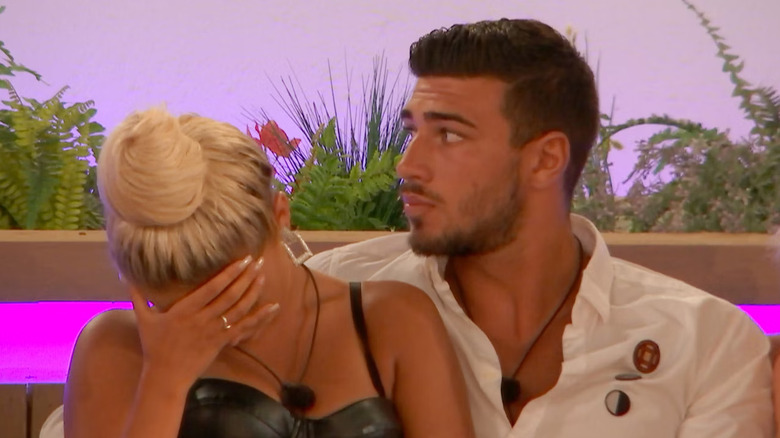 contestants Molly-Mae Hague and Tommy Fury sitting in a couple and reacting to many shock reveals from Casa Amor in "Love Island UK" Season 5