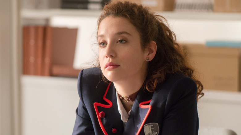 Marina sitting at a desk in "Elite."