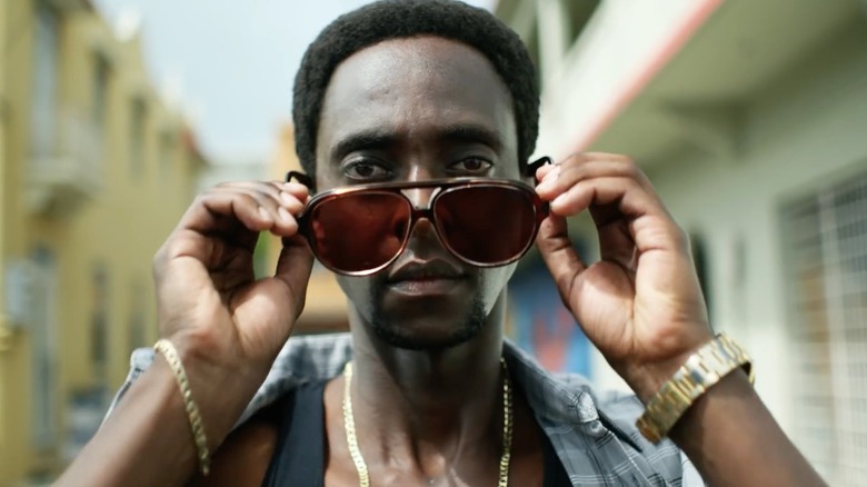 Ronald Dacey (Edi Gathegi) removing his sunglasses in "StartUp"