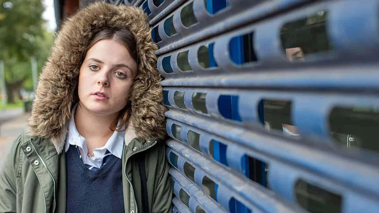 Bethan leaning against a building in "In My Skin."