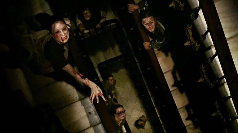 Infected apartment tenants climb a staircase in "[REC]" (2007)